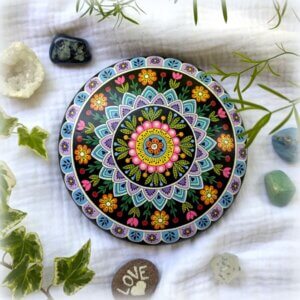 galet peint mandala poudre céramique fond noir